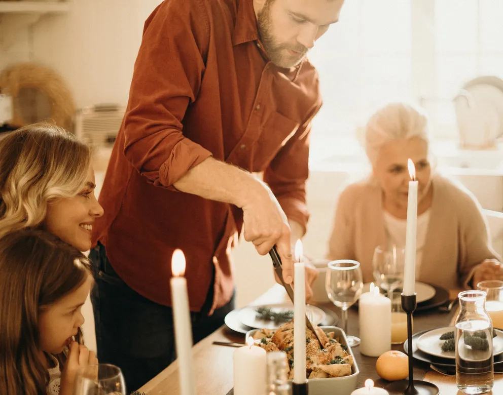 Varias personas compartiendo frente a una mesa con comida. | Foto: Pexels