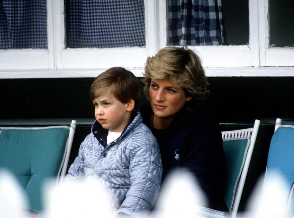 La princesse de Galles, Diana, avec son fils aîné, le prince William, assis sur ses genoux, au Polo de Windsor, au Royaume-Uni. | Source : Getty Images