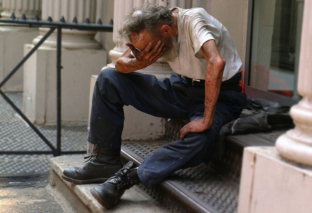 Un hombre sin hogar sentado sobre unos escalones. | Foto: Unsplash