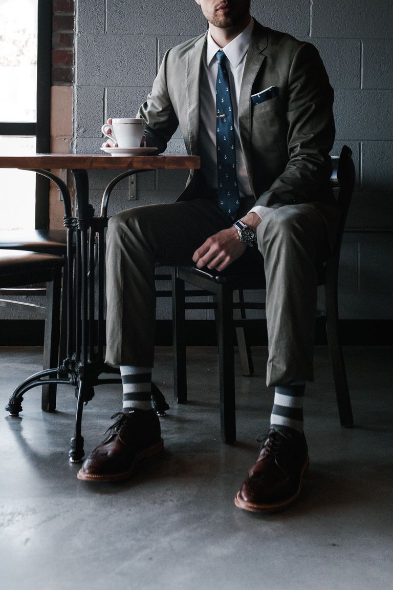 Un hombre vestido de traje sentado en un café. | Foto: Pexels
