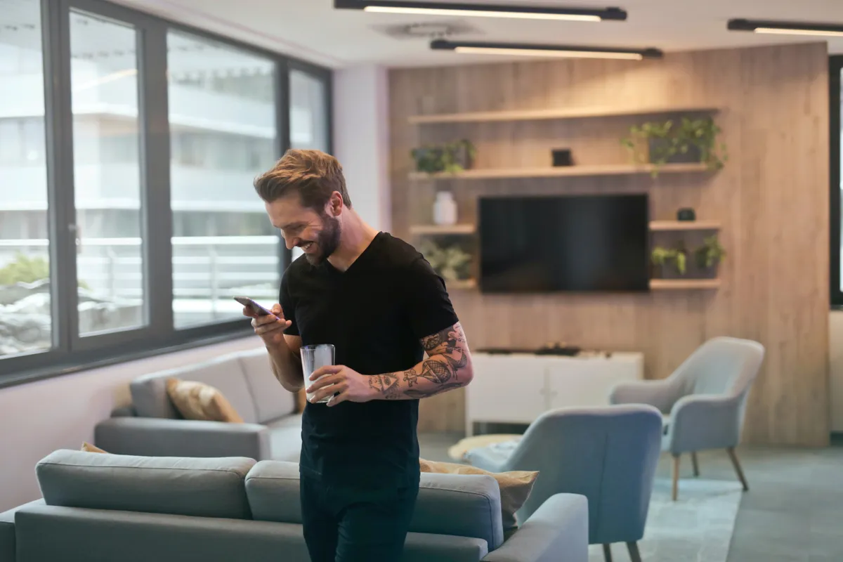 Un homme regarde son téléphone dans sa main. | Photo : Pexels