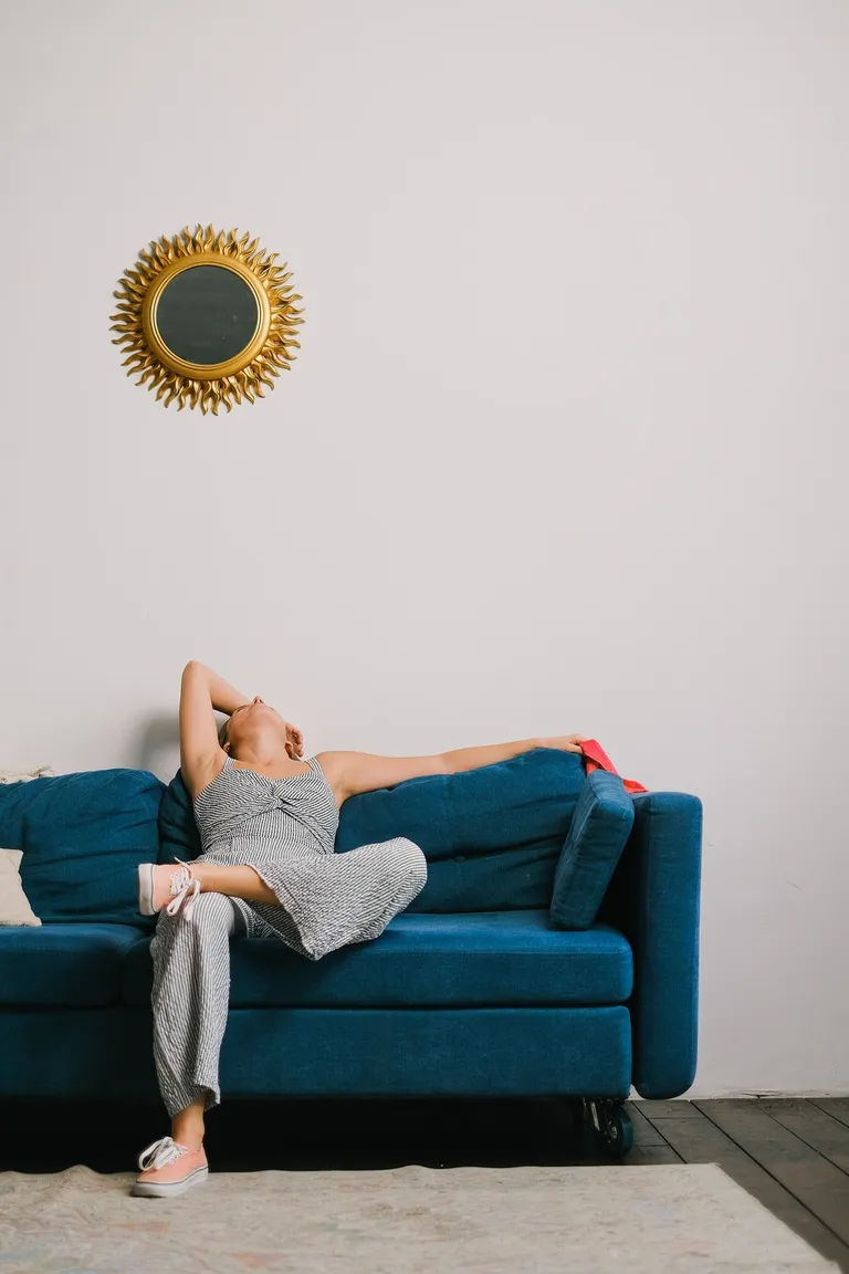 Mujer sentada en un sofá mientras se relaja. | Foto: Pexels