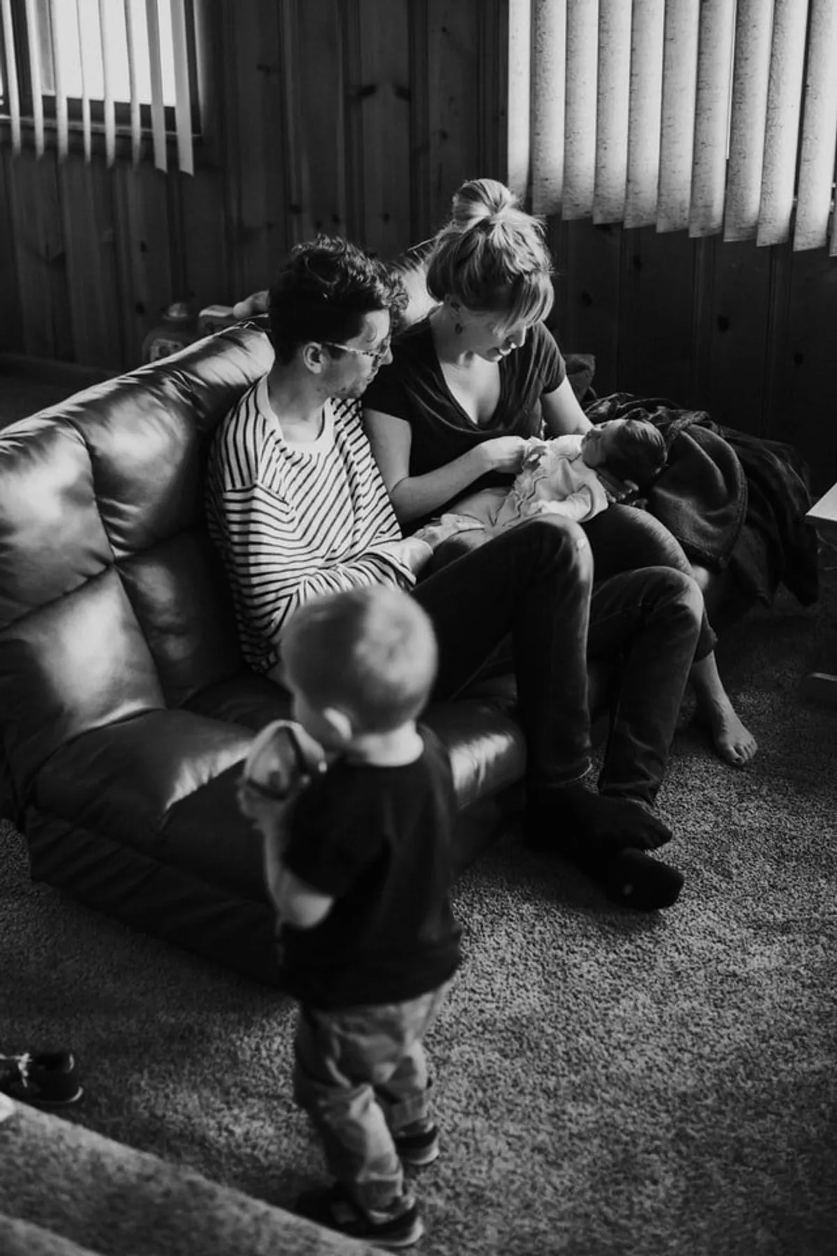 Photo en noir et blanc d'une famille dans un salon | Source : Unsplash