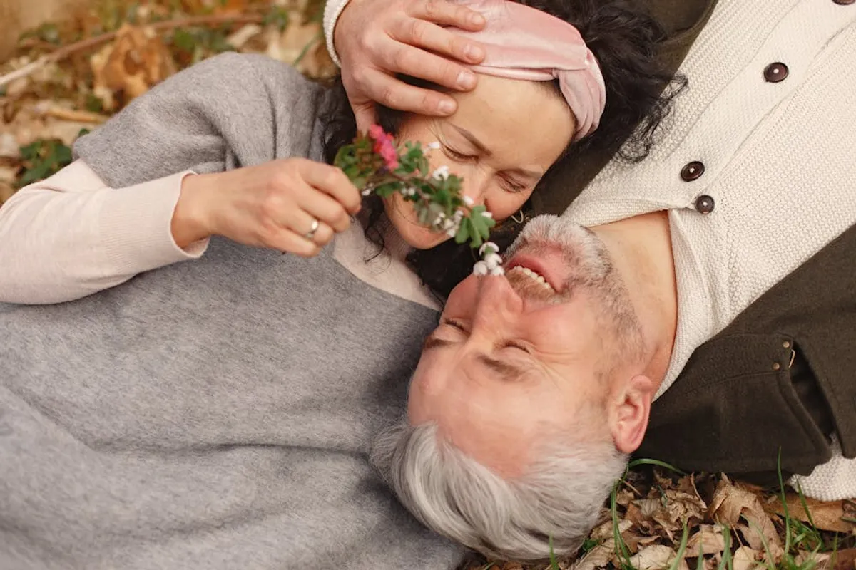 Senior couple lying on the grass together. | Photo: Pexels