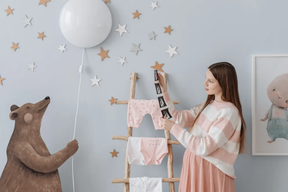 Una mujer embarazada decorando una habitación para su bebé. | Foto: Pexels