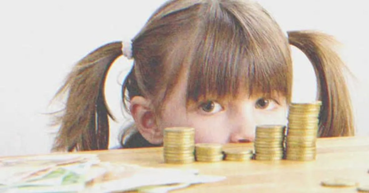 Niña frente a una pila de dinero. | Foto: Shutterstock