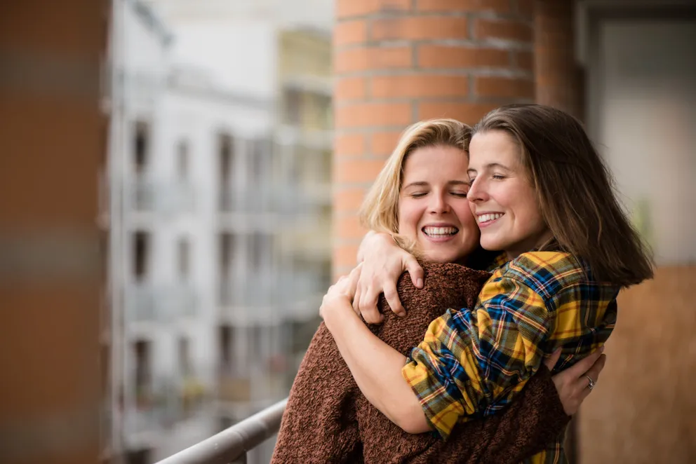 Retrato de gemelas sonriendo y abrazándose. | Foto: Getty Images