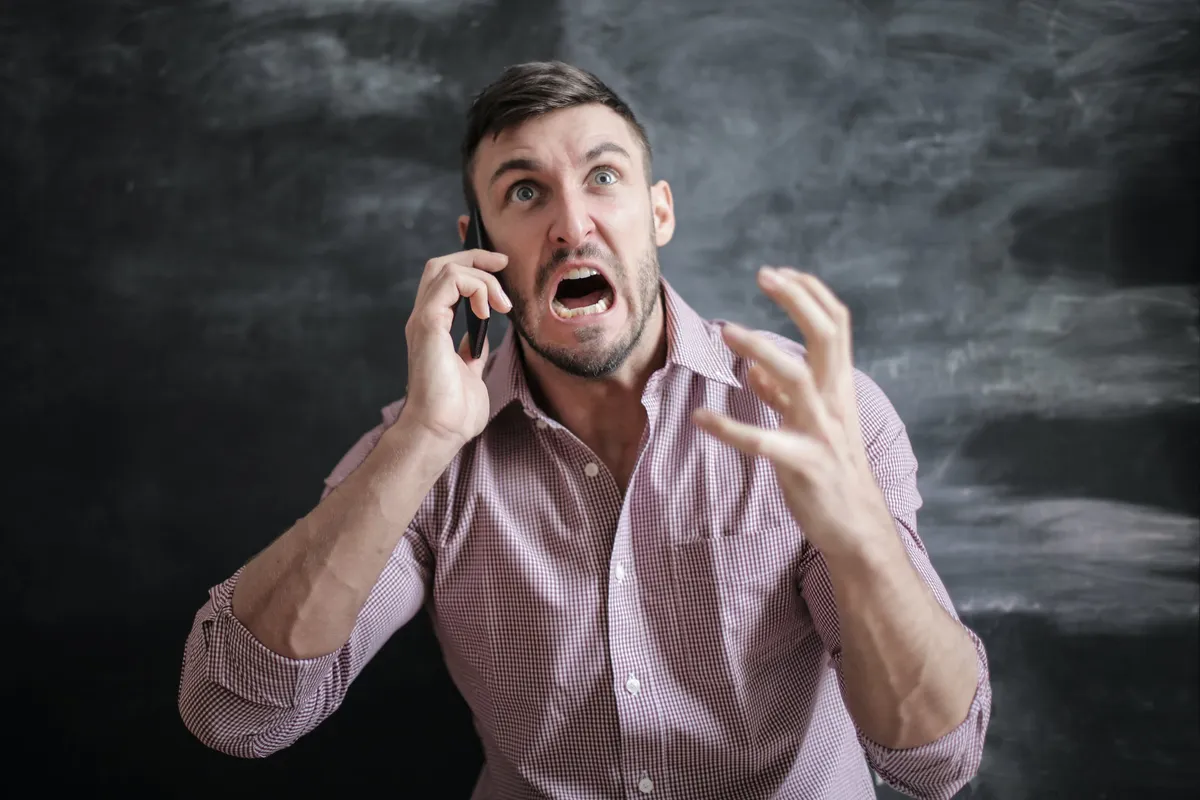 Hombre gritando mientras habla por teléfono. | Foto: Pexels