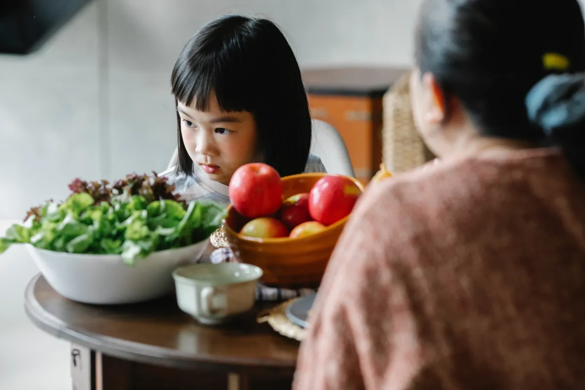 Une petite fille à table. | Photo : Unsplash
