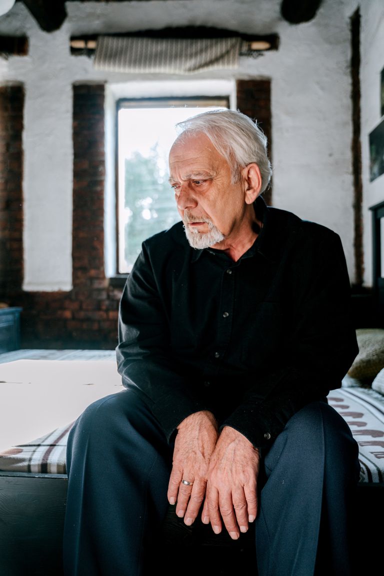 Anciano sentado a la orilla de su cama con rostro triste. | Foto: Pexels