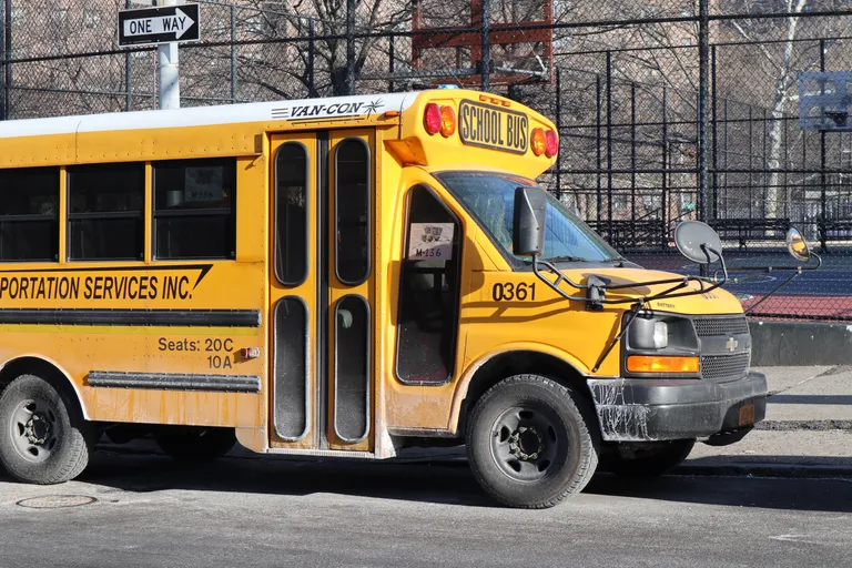 Un autobús escolar estacionado frente a las canchas de una escuela. | Foto: Unsplash