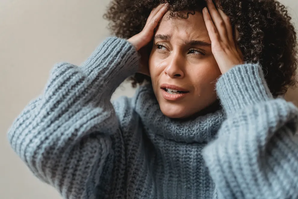 Una mujer angustiada con sus manos en su frente. | Foto: Pexels