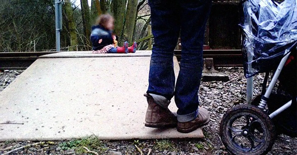 Un padre mira a su hija bebé sentada sobre las vías. | Foto: twitter.com/WalesOnline