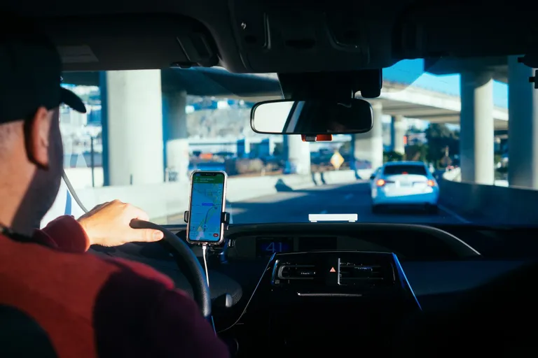 Hombre conduciendo un vehículo usando un GPS. | Foto: Unsplash