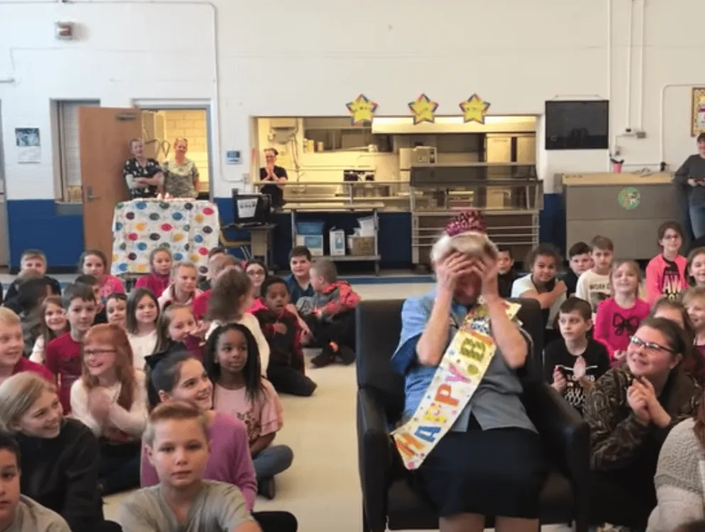 Estudiantes celebran el cumpleaños número 77 de la trabajadora de limpieza de la escuela. | Foto: Youtube/Charleston Gazette-Mail