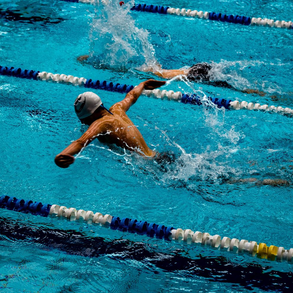 Un joven nadando en una piscina olímpica. | Foto: Unsplash
