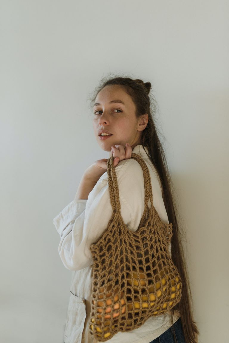 Una mujer sosteniendo una bolsa con frutas. | Foto: Pexels
