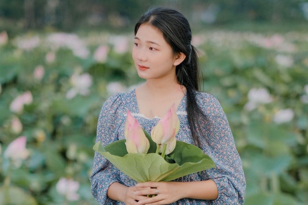 Una jovencita sosteniendo unas flores en sus manos. | Foto: Pexels