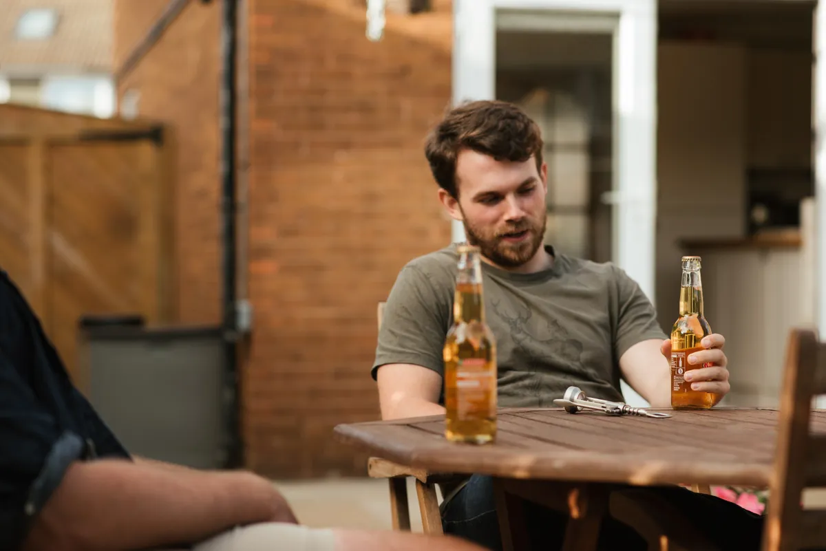 Hombre sentado en la mesa de un local mientras bebe unas cervezas. | Foto: Pexels