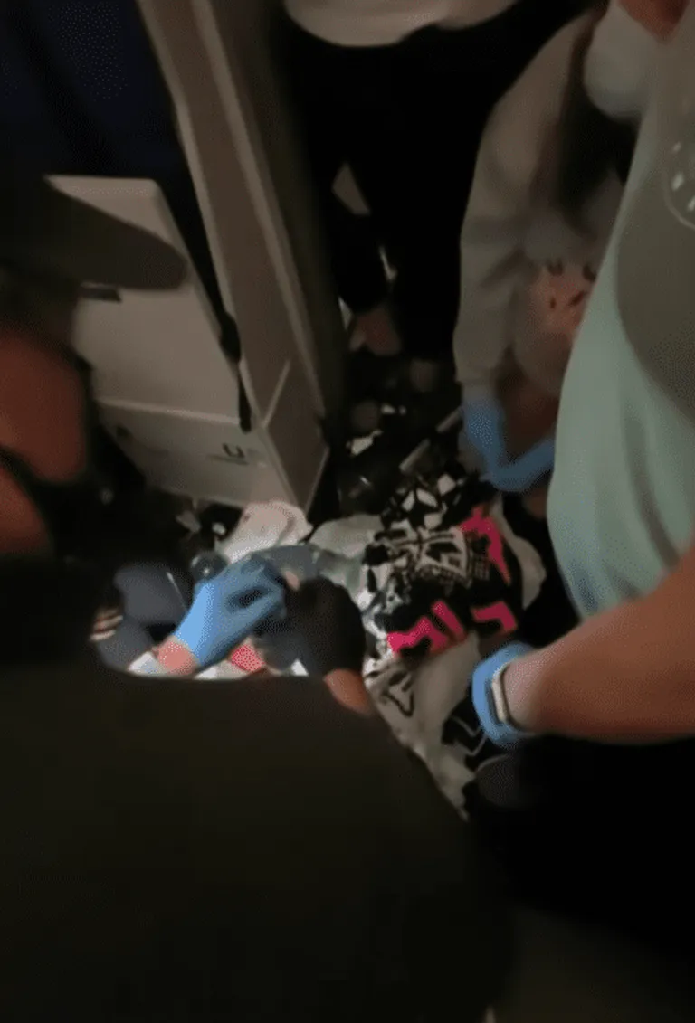 Enfermeras y médico a bordo de un avión se apresuran a ayudar a una mujer y a su bebé recién nacido. | Foto: Youtube.com/TheEllenShow