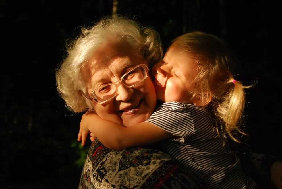 Anciana abrazando a una niña. | Foto: Unsplash