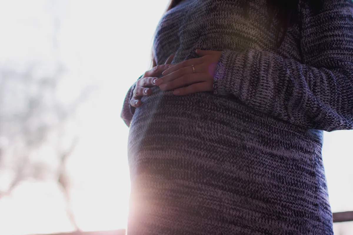 Mujer embarazada sosteniendo su vientre abultado. | Foto: Pexels