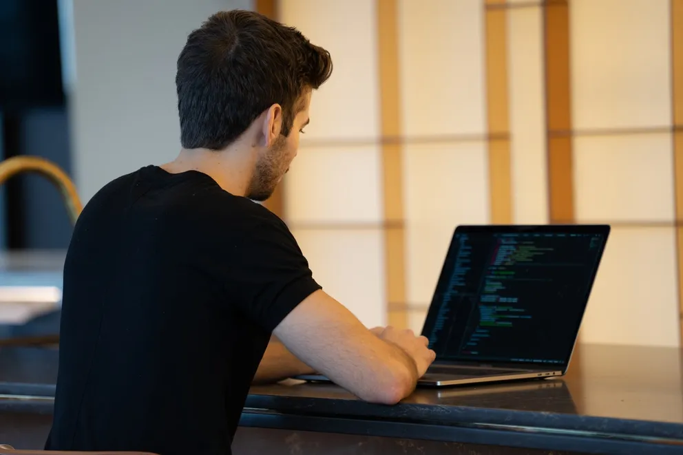 Un hombre escribiendo en una computadora portátil. | Foto: Unsplash