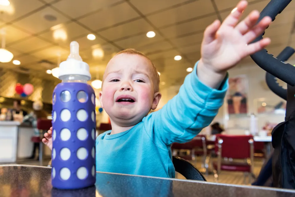 Un petit garçon pleure de façon incontrôlable dans un restaurant | Photo : Getty Images