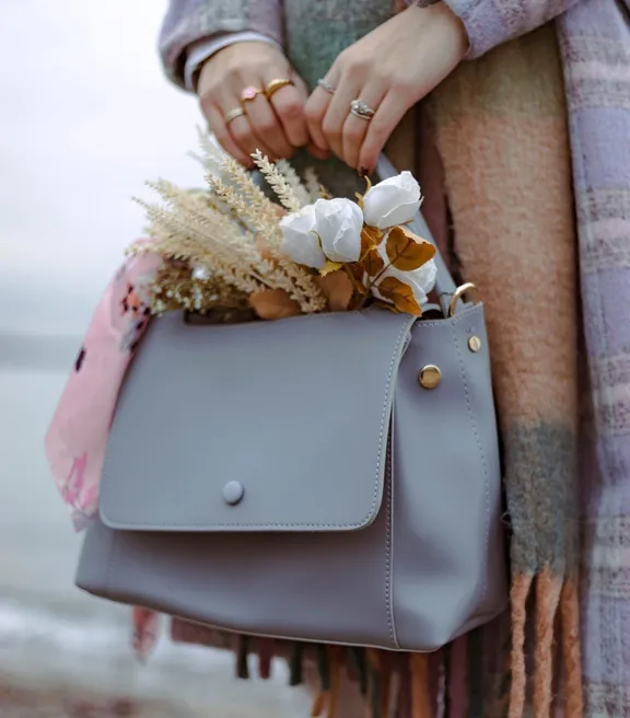 Una mujer con un abrigo sosteniendo un bolso. | Foto: Pexels