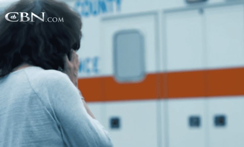 Pam debout près d'une ambulance. | Source : Youtube.com/The 700 Club