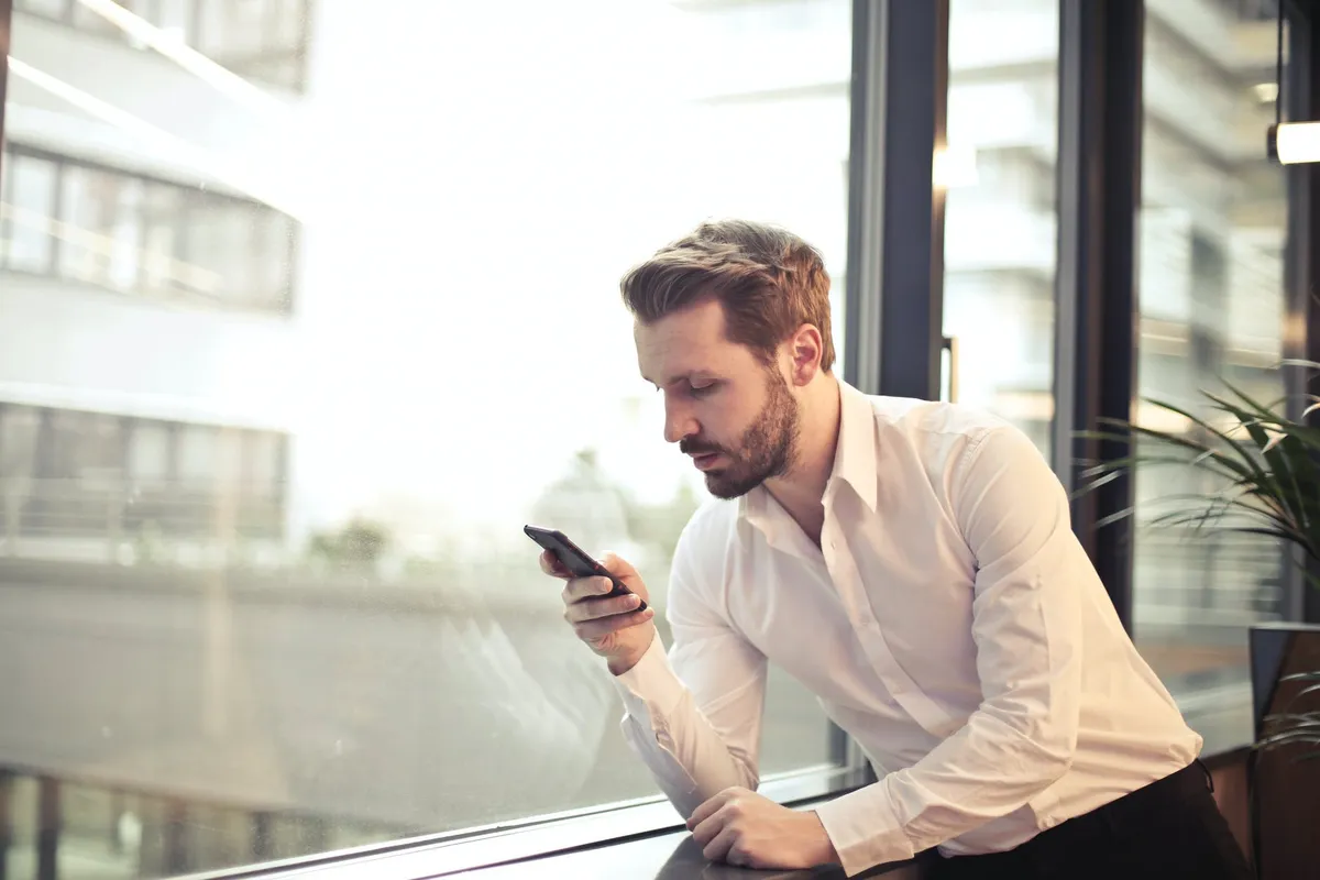 Un homme tenant un téléphone. | Photo : Shutterstock