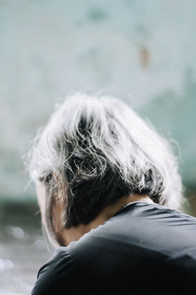 Una mujer mayor con la cabeza inclinada. | Foto: Unsplash