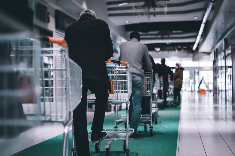 Compradores en un supermercado haciendo fila con sus carritos de compras. | Foto: Unsplash