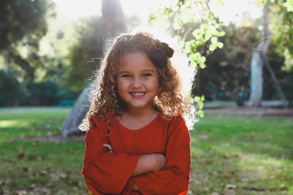 Una niña sonriendo en un parque. | Foto: Unsplash