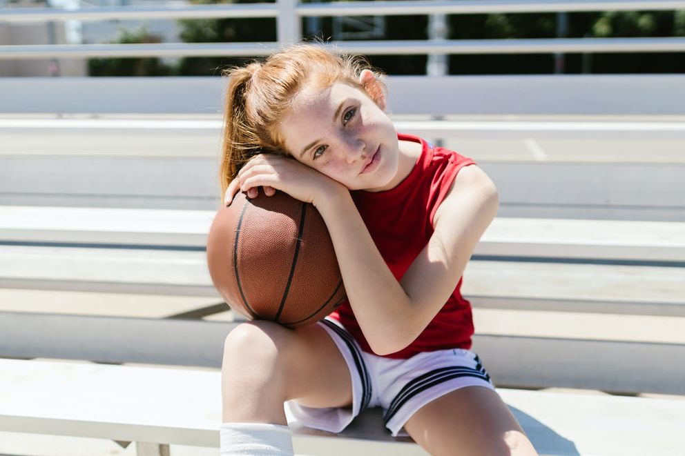 Una niña sosteniendo un balón de baloncesto. | Foto: Pexels