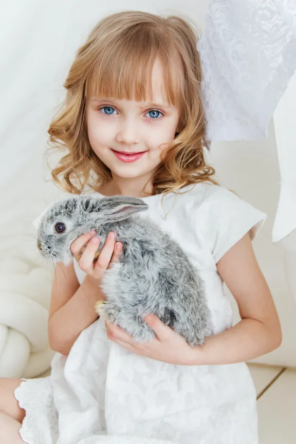 Una niña sosteniendo un pequeño conejo. | Foto: Pexels