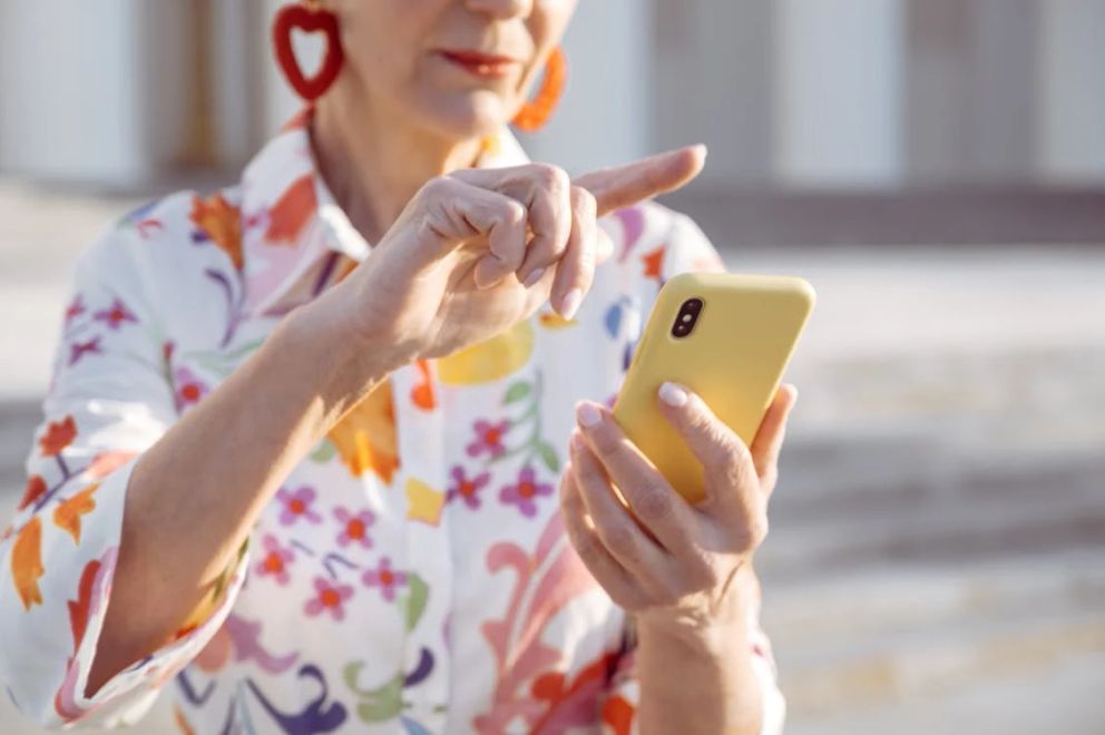 Una mujer mayor con un teléfono celular en su mano. | Foto: Pexels