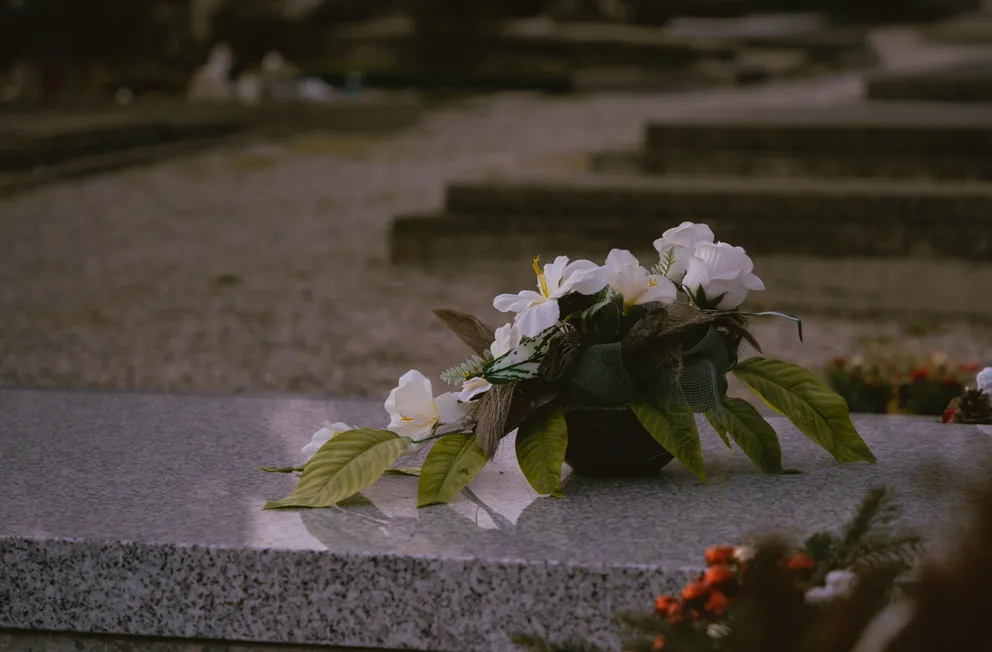 Un ramo de flores sobre una tumba en un cementerio. | Foto: Unsplash