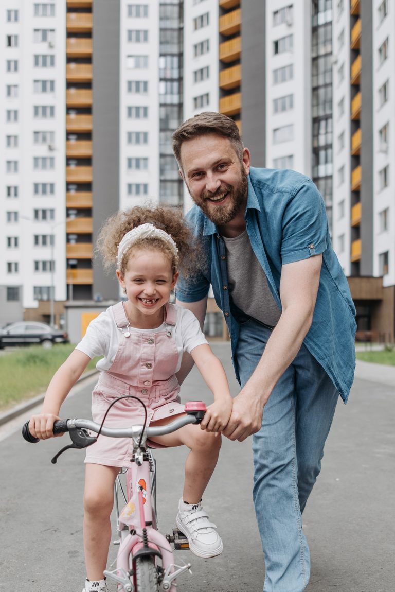 Un hombre enseñando a su hija a montar en bicicleta. | Foto: Pexels