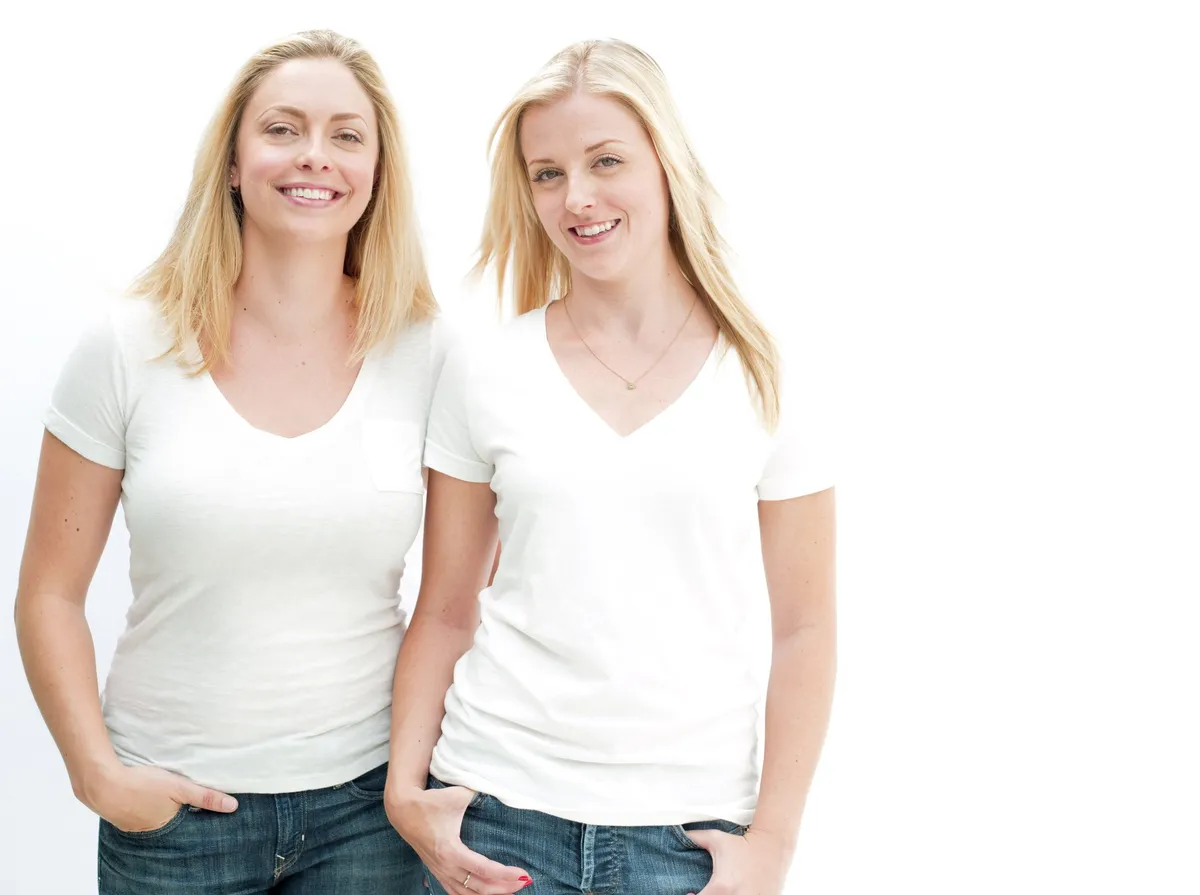 Porträt von zwei Blondinen in weißen T-Shirts, die lächeln. | Quelle: Getty Images