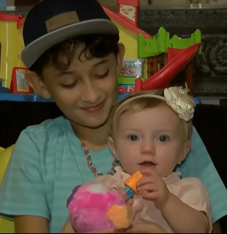 Jayden Fontenot holds her little sister as she plays with her toys.|  Source: youtube.com/KPRC 2 Click2Houston