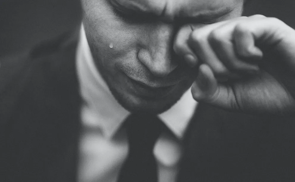 Un hombre llorando con su mano sobre su ojo. | Foto: Unsplash