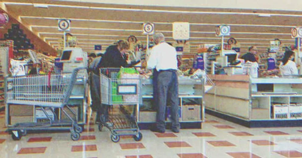 Un anciano y una mujer en la caja de un supermercado. | Foto: Shutterstock