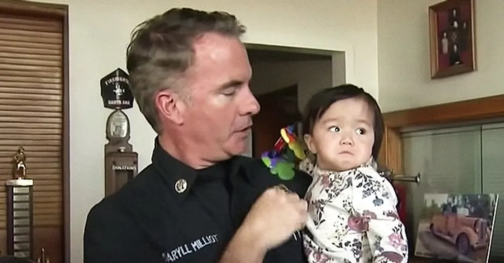 Bombero carga a Naomi. | Foto: Youtube.com/CBS Los Angeles