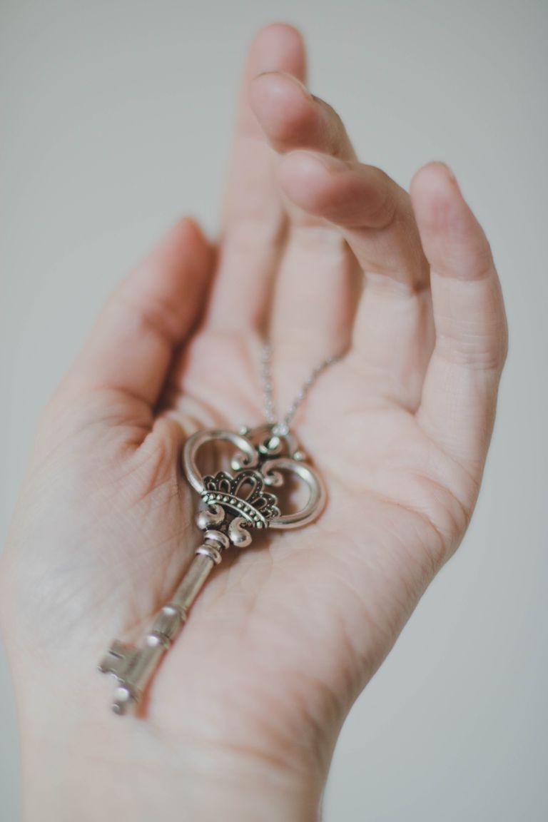 Una mujer sosteniendo una llave plateada en su mano. | Foto: Pexels
