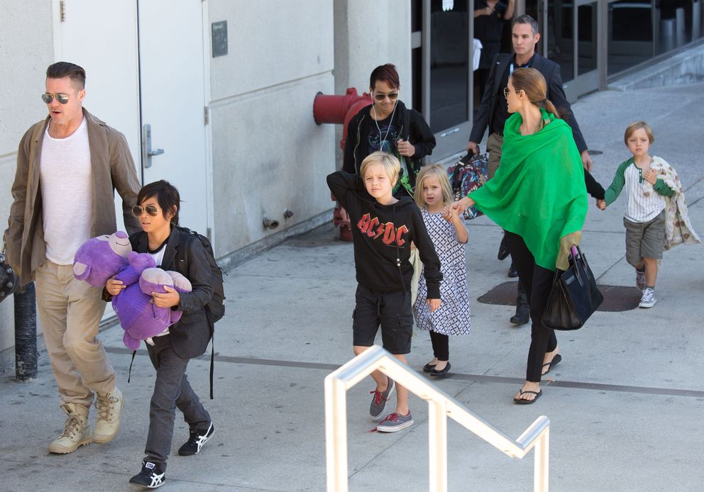 Brad Pitt y Angelina Jolie en el Aeropuerto Internacional de Los Ángeles con sus hijos Pax, Maddox, Shiloh, Vivienne y Knox Jolie-Pitt, el 5 de febrero de 2014 en Los Ángeles, California. | Foto: Getty Images