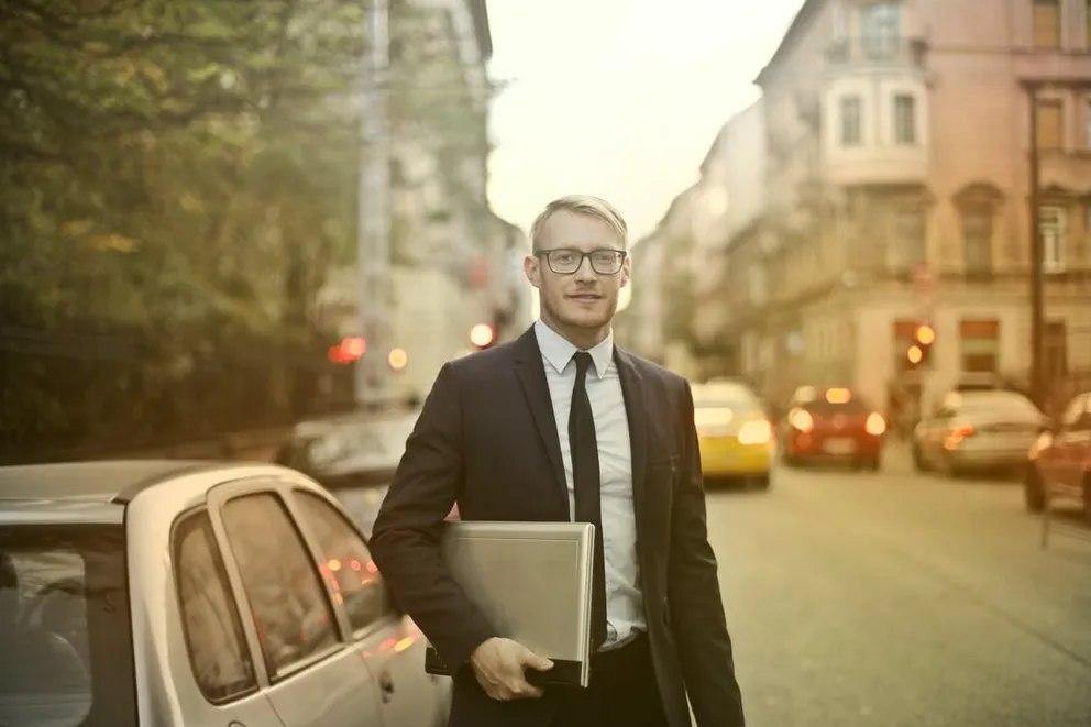 Vendedor posando con un computador portátil. │Foto: Pexels