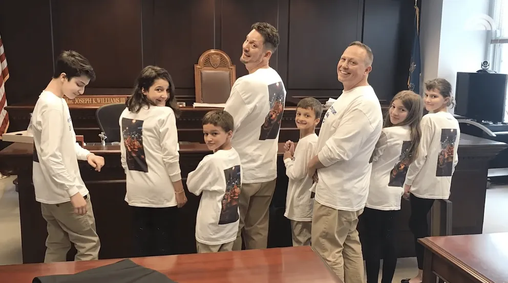 Steve et Rob, dans leurs t-shirts blancs assortis, avec les six frères et sœurs le jour de l'adoption. | Photo : YouTube.com/TODAY