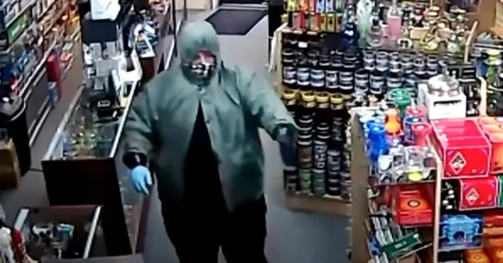 Un homme déguisé brandissant une arme dans un magasin.┃Source : youtube.com/WNCNTV