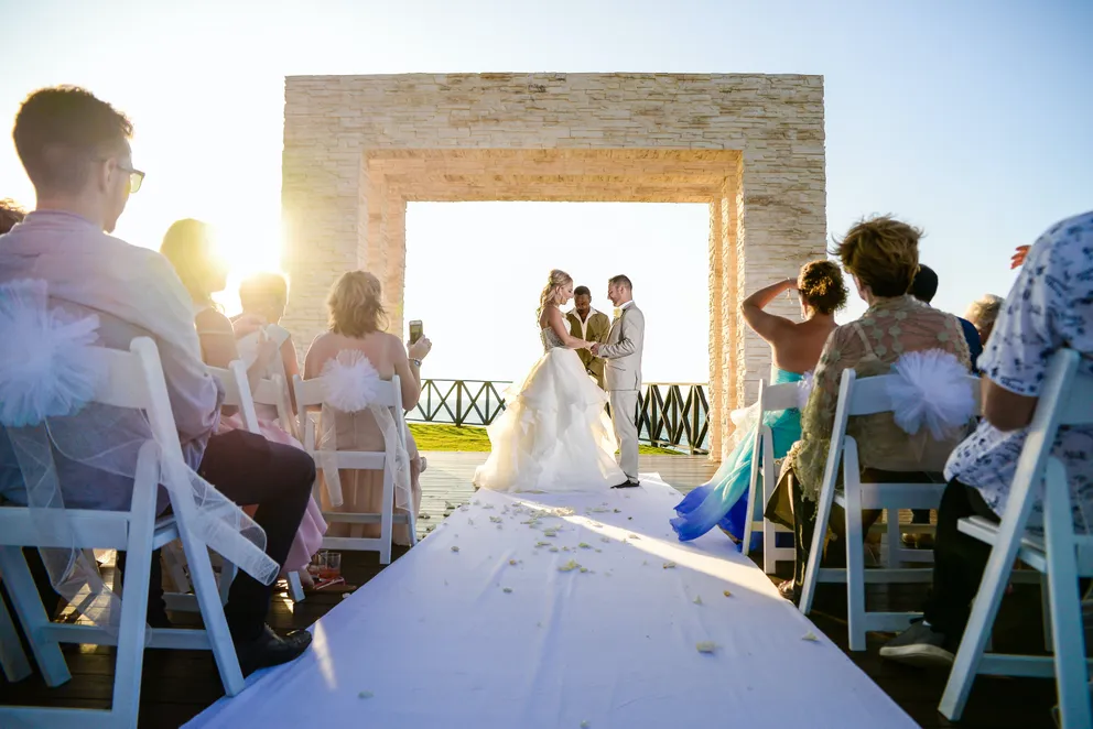 Una pareja celebrando su boda con invitados sentados observando la ceremonia. | Foto: Pexels